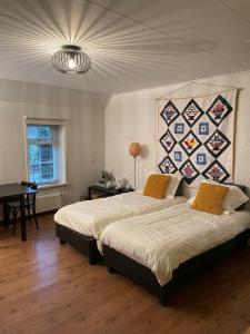 een slaapkamer met 2 bedden en een muur met een quilt bij de Stjelp Pleats in Lemmer