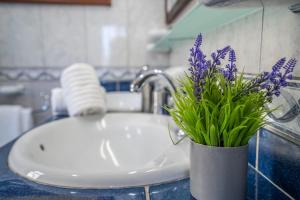 a bathroom sink with a vase with purple flowers in it at Villa La Laja with 5 bedrooms and sea view in Callao Salvaje +53 photos