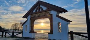 a small dog house with the sunset in the background at Przestronny, komfortowy dom in Swornegacie 