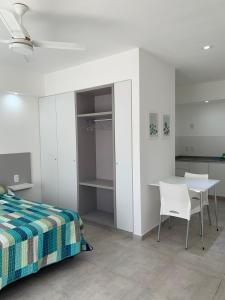 1 dormitorio con 1 cama, mesa y sillas en Aloha en Colón