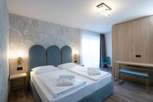 a bedroom with a large bed and a desk at Hotel Sole - Sonne in Dobbiaco