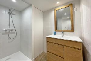 a bathroom with a sink and a shower and a mirror at L'appart' des Moussaillons in La Flotte