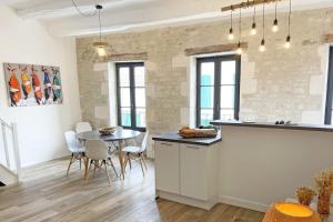 a kitchen and dining room with a table and chairs at L'appart' des Moussaillons in La Flotte