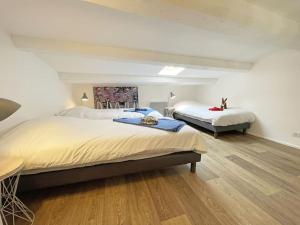 een slaapkamer met 2 bedden en een houten vloer bij L'appart' des Moussaillons in La Flotte
