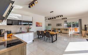 a kitchen and living room with a table and chairs at Istriensonne 0005 - Villa Maristra mit Pool in Šišan