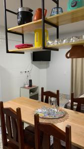 a dining room table with chairs and shelves at Lagoa Quente Flat Service in Caldas Novas