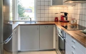 una cocina con armarios blancos y fregadero en 3 Bedroom Cozy Home In Morgongva, 