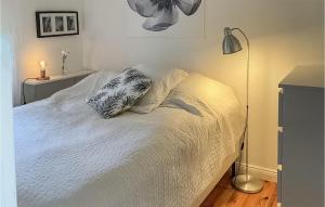 Cama blanca con almohada y lámpara en 3 Bedroom Cozy Home In Morgongva, 