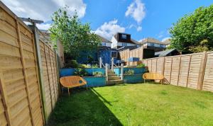 a backyard with two chairs and a fence at The Bee House Brighton. A holiday home by the sea. in Brighton & Hove
