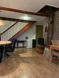 a living room with a table and chairs and a staircase at de Stjelp Pleats in Lemmer