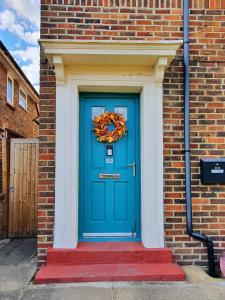 a blue door with a wreath on a brick building at The Bee House Brighton. A holiday home by the sea. in Brighton & Hove