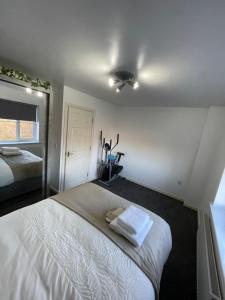 a bedroom with a white bed and a ceiling fan at Hensh Homes in Saint Helens