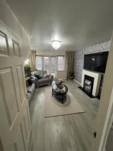 a living room with a couch and a table at Hensh Homes in Saint Helens