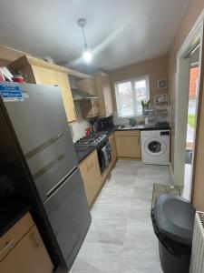 a kitchen with a refrigerator and a stove at Hensh Homes in Saint Helens