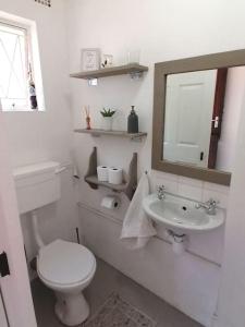 a white bathroom with a toilet and a sink at Finsbury Fortress - Self-catering Studio in East London