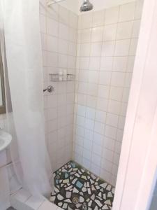 a bathroom with a shower with a tile floor at Finsbury Fortress - Self-catering Studio in East London