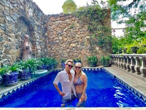 a man and a woman standing next to a swimming pool at Casa Schuck Boutique Hotel in San Miguel de Allende