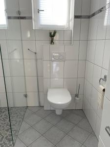 a white bathroom with a toilet and a window at Ferienwohnung Bett & Burg in Wertheim +16 photos