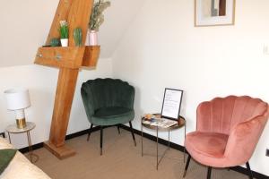 twee stoelen en een tafel in een kamer bij Chez Pierrette à deux pas du Château de Meursault in Meursault