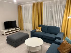 sala de estar con sofá azul y TV en Fengrande en Karpacz