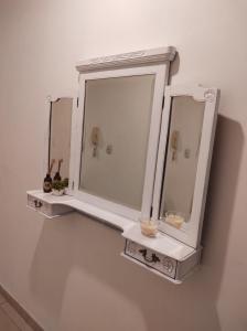 a white medicine cabinet with two mirrors on a wall at Studio Puerto Escobar, 2 ambientes in Belén de Escobar