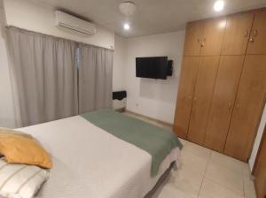 a bedroom with a bed and a flat screen tv at Studio Puerto Escobar, 2 ambientes in Belén de Escobar