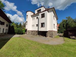 un grand bâtiment blanc avec une pelouse dans l'établissement Vila Šik 2, à Nové Město na Moravě