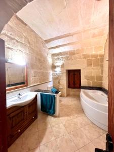 y baño con bañera, lavamanos y bañera. en Birbuba House 2 en Għarb