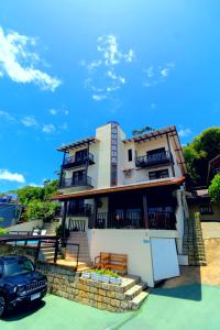uma casa com um carro estacionado na frente dela em Pousada Al Mare em Bombinhas