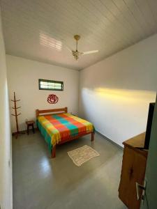 1 dormitorio con 1 cama colorida en una habitación en Casa Pau Brasil, en Prado