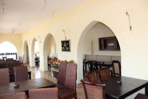 Qaryat at Ta‘mīr as SiyāḩīyahLake House by Tunisia Green Resort的一间带拱门和桌椅的用餐室