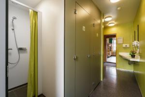 a bathroom with green and white walls and a walk in shower at Backpackers Villa Sonnenhof - Hostel Interlaken in Interlaken
