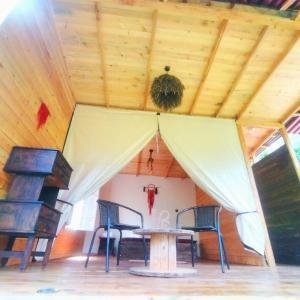 Habitación con mesa y sillas bajo el techo. en Hostal Payaca, en Bituima