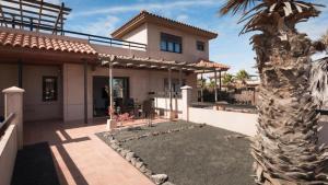 a house with a palm tree in front of it at Paradise Island in Lajares