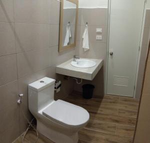 SBG Resort Lambug في باديان: حمام به مرحاض أبيض ومغسلة