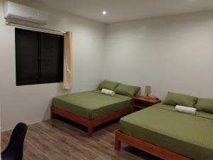 una piccola stanza con due letti e una finestra di SBG Resort Lambug a Badian