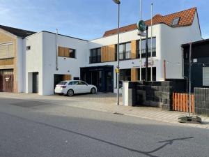 een witte auto geparkeerd voor een gebouw bij L'Imeri Residence in Reilingen