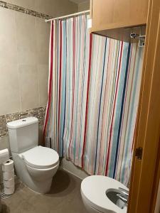 uma casa de banho com um WC e uma cortina de chuveiro em Precioso apartamento en zona residencial em Panticosa