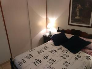 Un dormitorio con una cama con escritura asiática. en Dpto Hipólito Yrigoyen en Concordia