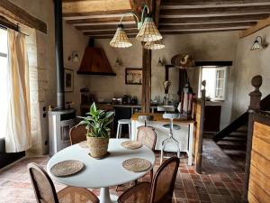 cocina y comedor con mesa y sillas en Gîte des 3 Marchands, en Buzançais
