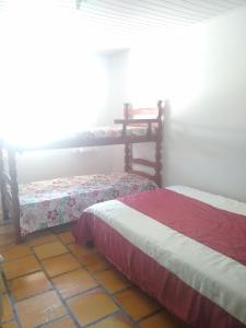 two beds sitting in a room with at Casa ampla a 50metros do mar in Balneario Barra do Sul