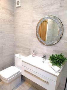 uma casa de banho com um WC branco e um espelho. em New COSY HOMES em Newhaven