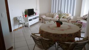 een woonkamer met een tafel en stoelen bij Residencial Ilha Verde (201) in Florianópolis