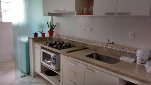 cocina con fregadero y fogones en Residencial Ilha Verde (201), en Florianópolis