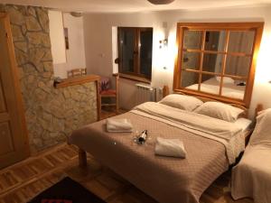1 dormitorio con 2 camas y pared de piedra en Vila Boska Palic, en Palić