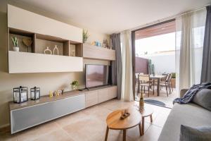 a living room with a couch and a tv and a table at Villa La Laja with 5 bedrooms and sea view in Callao Salvaje