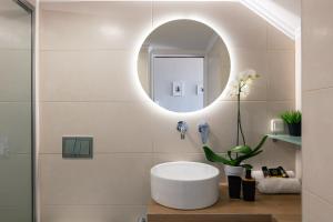 a bathroom with a round sink and a mirror at AnnaView Apartments & Suites in Plakias