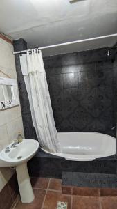 W łazience znajduje się umywalka, wanna i toaleta. w obiekcie Casa del Bosque w mieście Mar del Plata