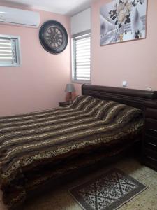 a bedroom with a large bed and a clock on the wall at Private room in the сomfortable apartment in Ashdod, 7 min walk to the beach in Ashdod