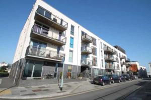 a white building with cars parked in front of it at Lovely 1 Bedroom Apartment in Plymouth